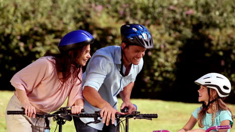 parents and children pointing the way to go while they are riding bicycle