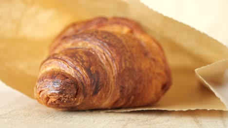 un delicioso croissant en una bolsa de papel