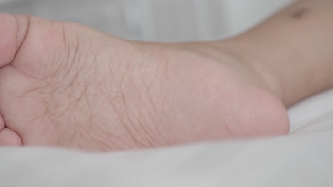 child's foot on a white sheet