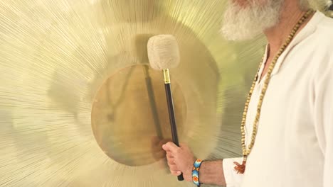 crop spiritual practitioner with hammer playing gong