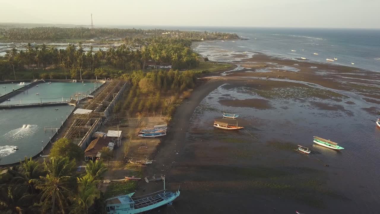 toma aérea hacia atrás de la costa de java con barcos con marea baja