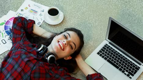 Female-graphic-designer-relaxing-on-floor