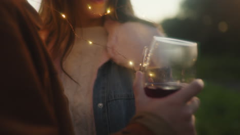 una pareja bebe vino en el parque antes del día de la boda.