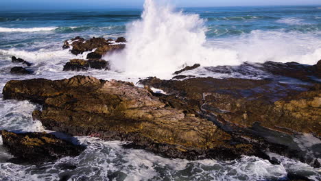 waves crash violently against rugged coastline - frothing seawater