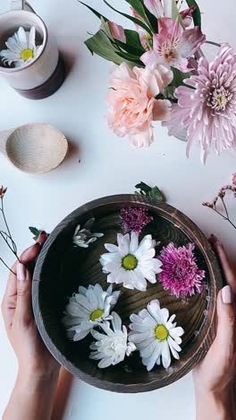 floral arrangement in wooden bowl with teacup and spoon