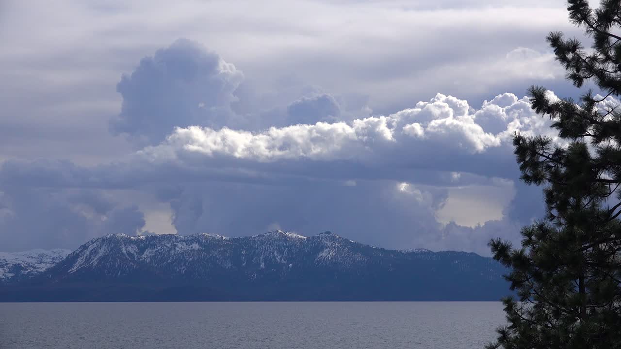 눈 덮힌 탈락 산과 캘리포니아 타호 호수 근처의 황폐한 황무지 뒤에 떠오르는 뇌우 구름 형성의 아름다운 시간 경과
