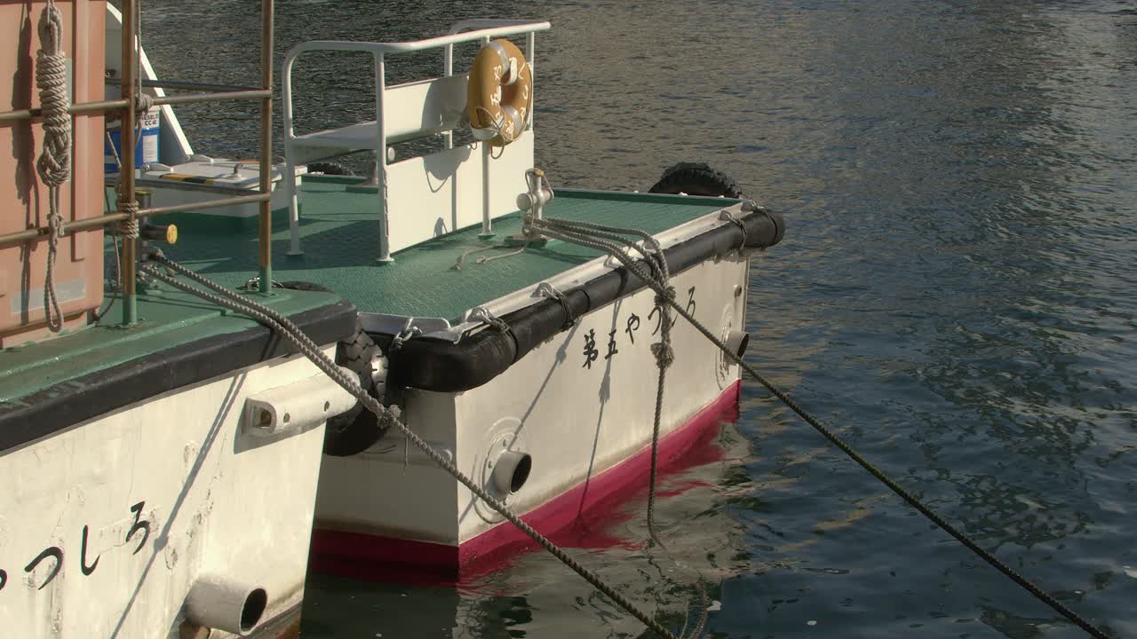 Due navi ormeggiate al porto di Kobe, in Giappone, ondeggiano sulle onde leggere