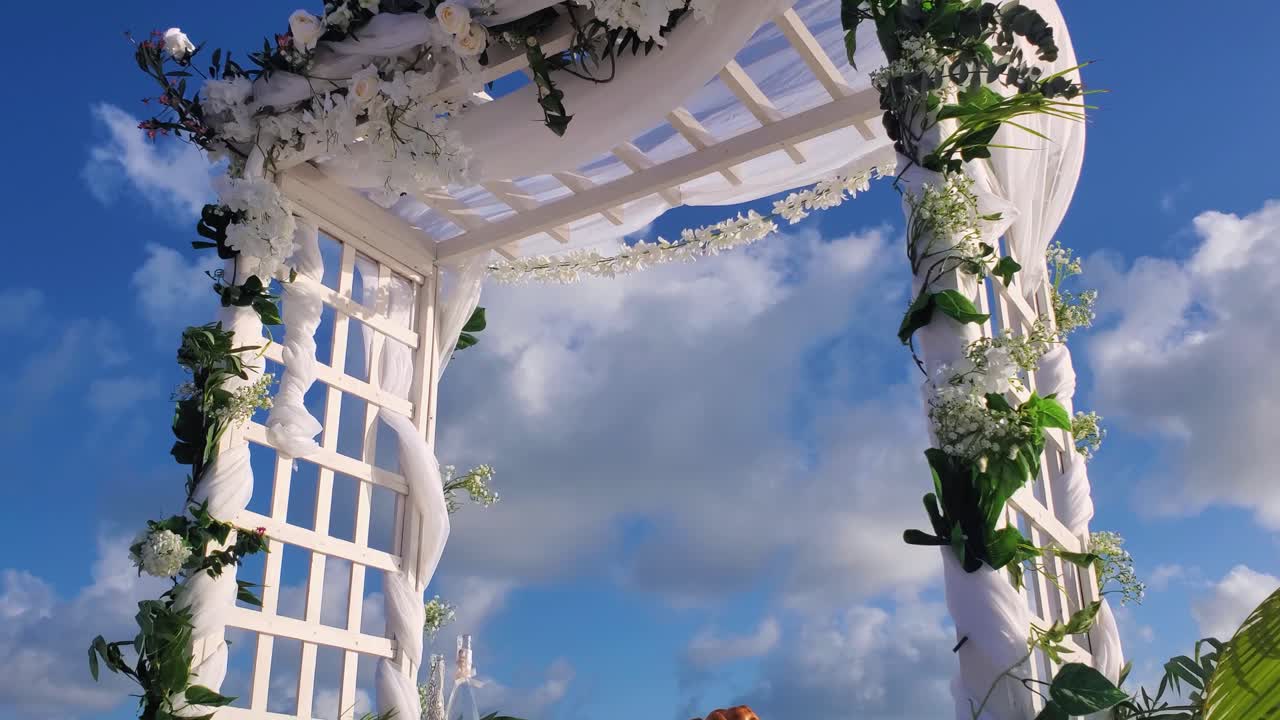 Arco nuziale, gazebo su spiaggia tropicale decorato con fiori, decorazione per matrimonio in spiaggia