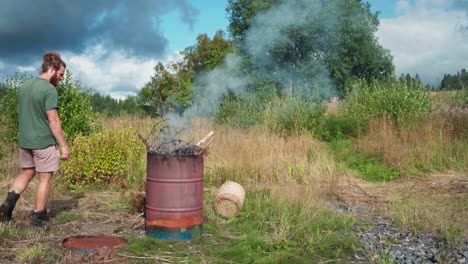 a man is burning the dried plants in indre fosen, trondelag county, norway - static shot