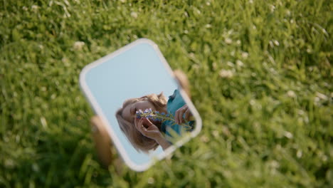 woman smelling flowers in a handheld mirror