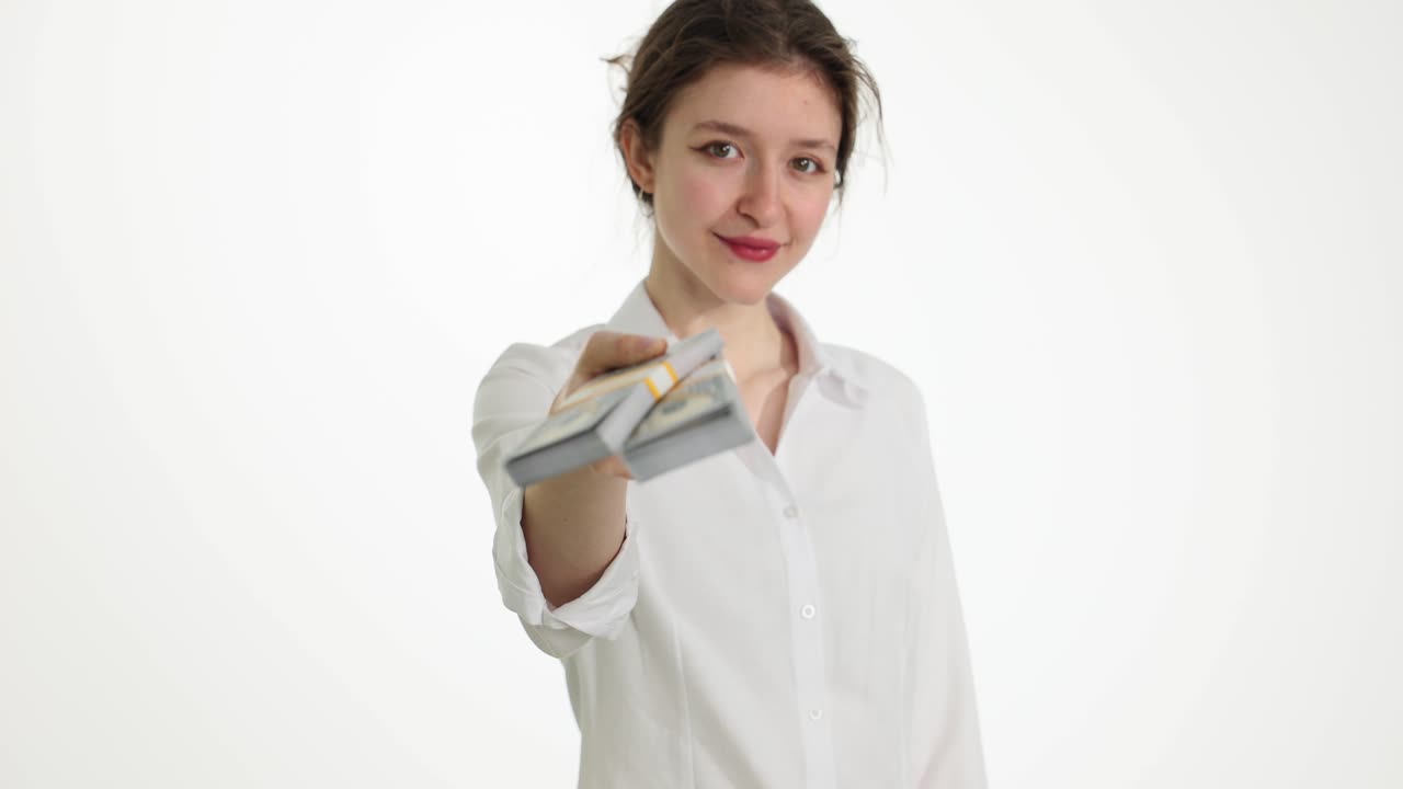 Young woman holding out stacks of money