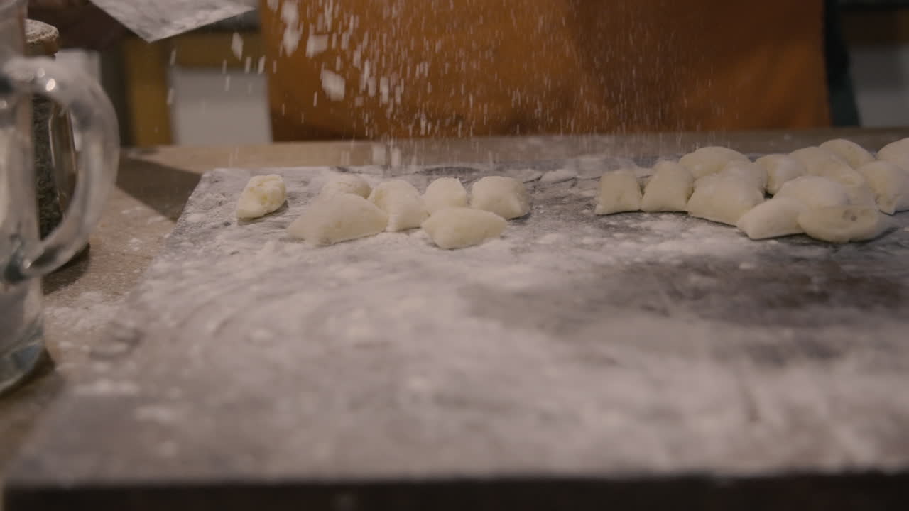 Chef's Hand Shaping Fresh Gnocchi Dough with Flour
