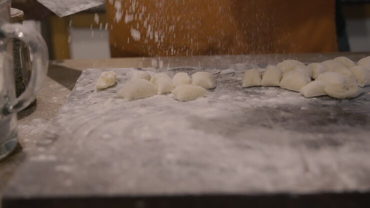 Chef's Hand Shaping Fresh Gnocchi Dough with Flour