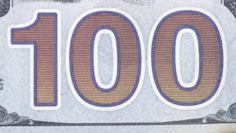 close up of "100" on us 100 dollar bill burning, inflation concept