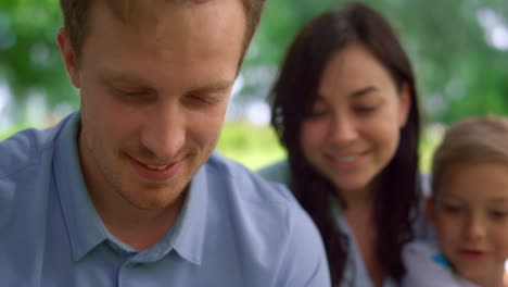 Portrait-man-watching-tablet-on-picnic-closeup.-Family-rest-with-modern-gadget.