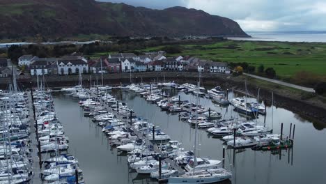 luxurious yachts moored in wealthy welsh mountain marina aerial view orbiting left shot