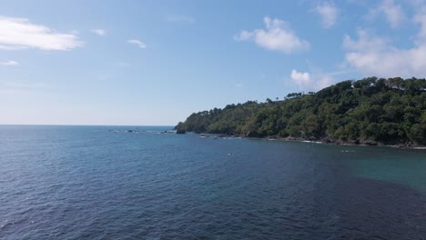 Approaching-drone-flight-towards-a-lush-tropical-peninsula-on-Costa-Rica's-pacific-shore