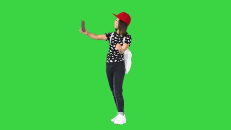 asian school girl taking selfie on a green screen, chroma key