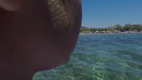 POV-Folgeaufnahme-Eines-Kaukasischen-Kindes,-Das-Sich-Darauf-Vorbereitet,-Ins-Meer-Zu-Springen,-Ein-Schwimmbrett-In-Der-Hand-Hält,-Einen-Badeanzug-Und-Eine-Seebrille-Trägt,-60-Fps