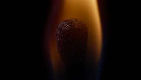 close up of one match head burning on black background. matches lighting in slow motion. fire ignition with matches. macro view.