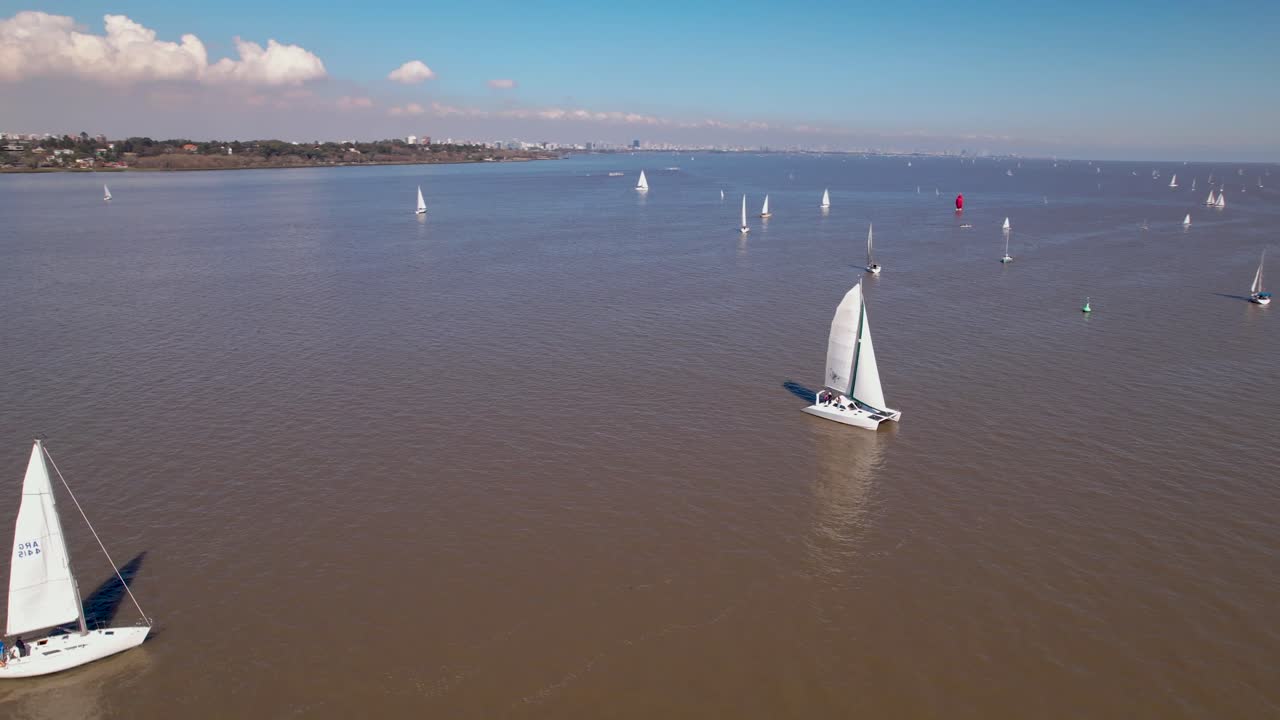 catamarán navegando con una flota en el río reluciente - panorámica aérea
