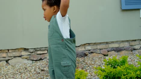 front view of cute little black baby playing in back yard of their home 4k