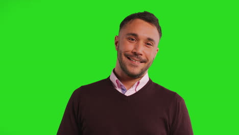 retrato de estudio de cerca de un maestro o hombre de negocios de pie contra una pantalla verde sonriendo