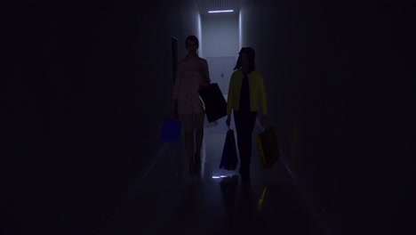 two women shopping in a mall corridor at night