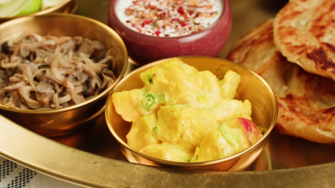 A vibrant platter featuring a variety of traditional Indian dishes, including curries, chutneys, and flatbreads.