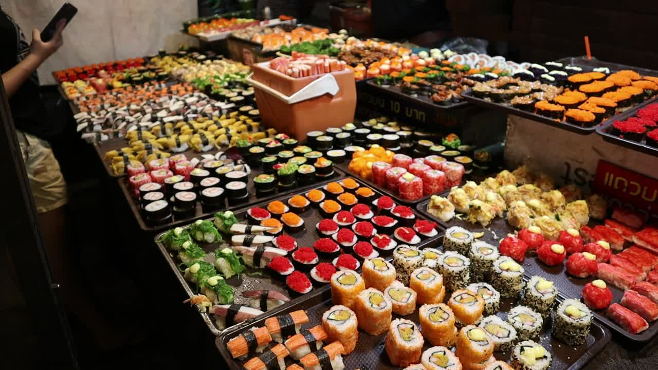 Popular Saturday Night Market Street Food in Chiang Mai, Thailand. A wide selection of Thai street food sushi. A lively and fun night market