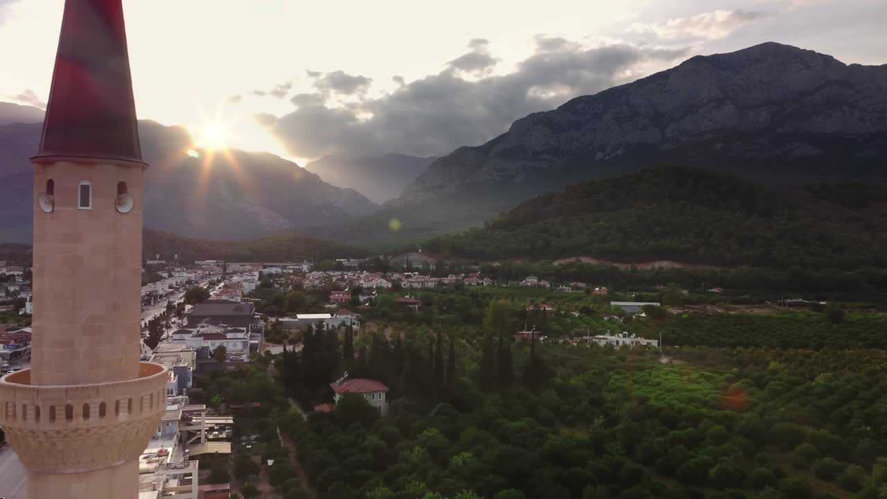 vista de la ciudad de kemer y la mezquita islámica con montañas y puesta de sol en el fondo filmada por avión no tripulado