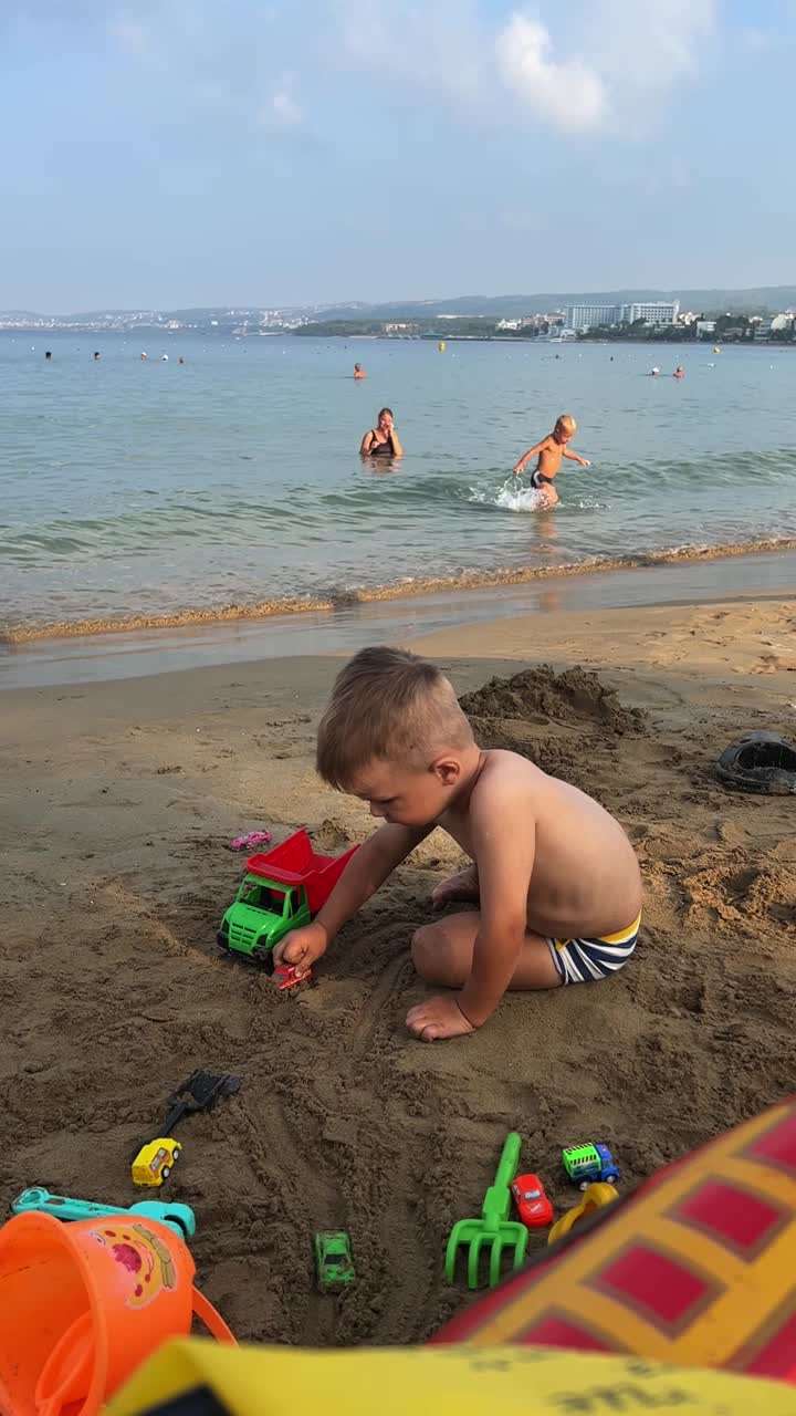 Boy playing on the beach with toys