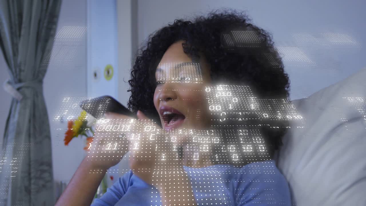 Una donna sdraiata preme pulsanti su un telecomando e pronuncia comandi, usando un'interfaccia tecnologica con sovrapposizione binaria.