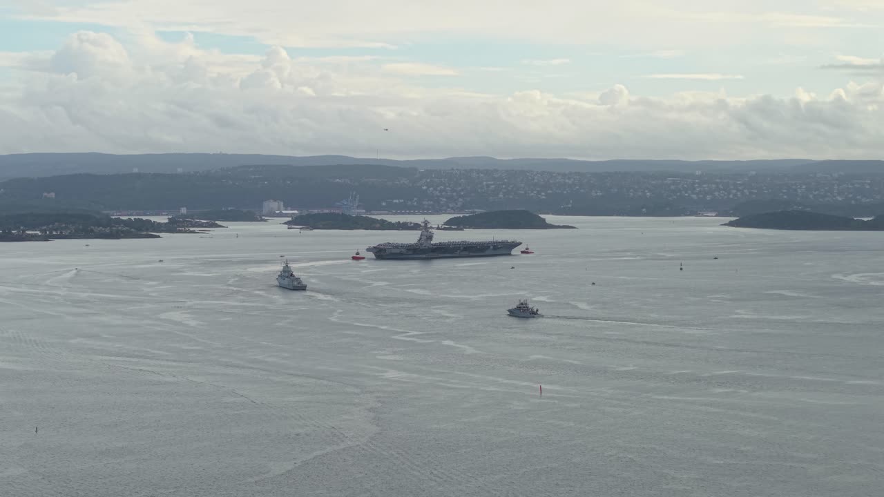 Aircraft Carrier USS Gerald R. Ford In The Fjord With Nearby Islands In Oslo, Norway. - aerial shot
