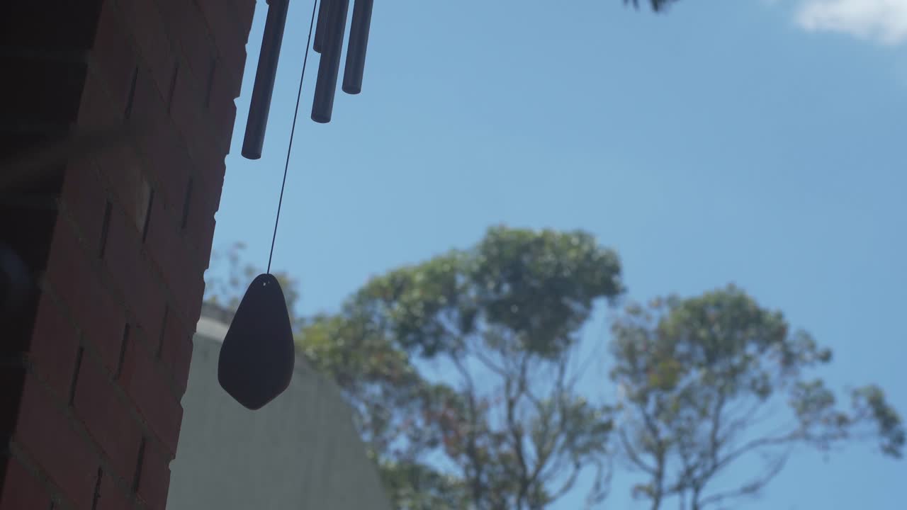 벽돌 벽 옆에 있는 바람 종소리