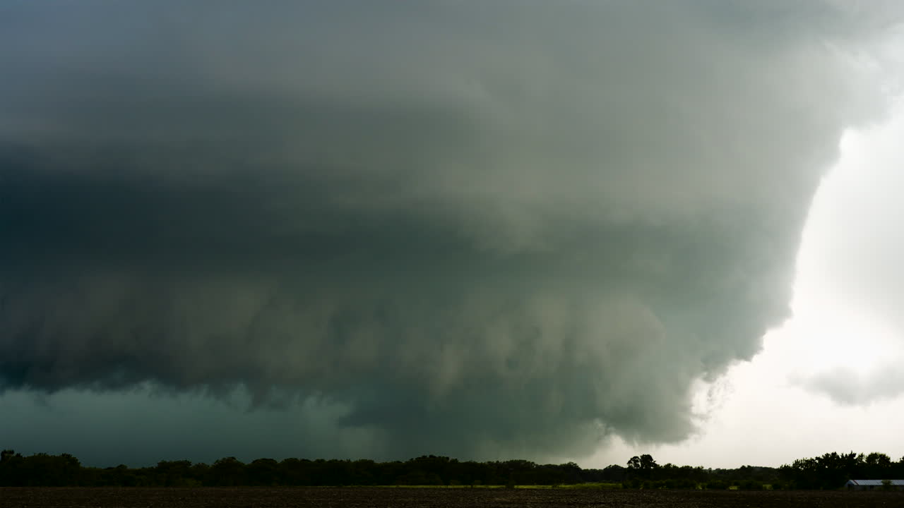 Powerful supercell thunderstorm spins across open fields