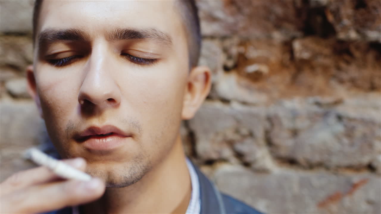 retrato de un joven fumando desesperadamente en un concepto de casa abandonada - problema de soledad de depresión