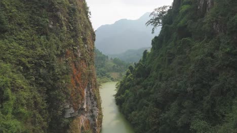 soar above a winding river flowing through a canyon in ha giang’s thick jungle. this stunning aerial footage captures the untouched beauty of northern vietnam’s vibrant landscapes.