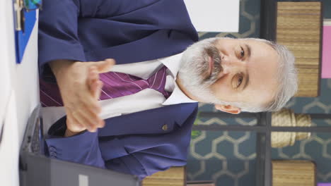 Vertical-video-of-Old-businessman-clapping-while-looking-at-camera-with-pride-and-joy.