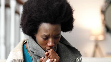 cierra el retrato de una mujer afroamericana con una bufanda, sentada en casa