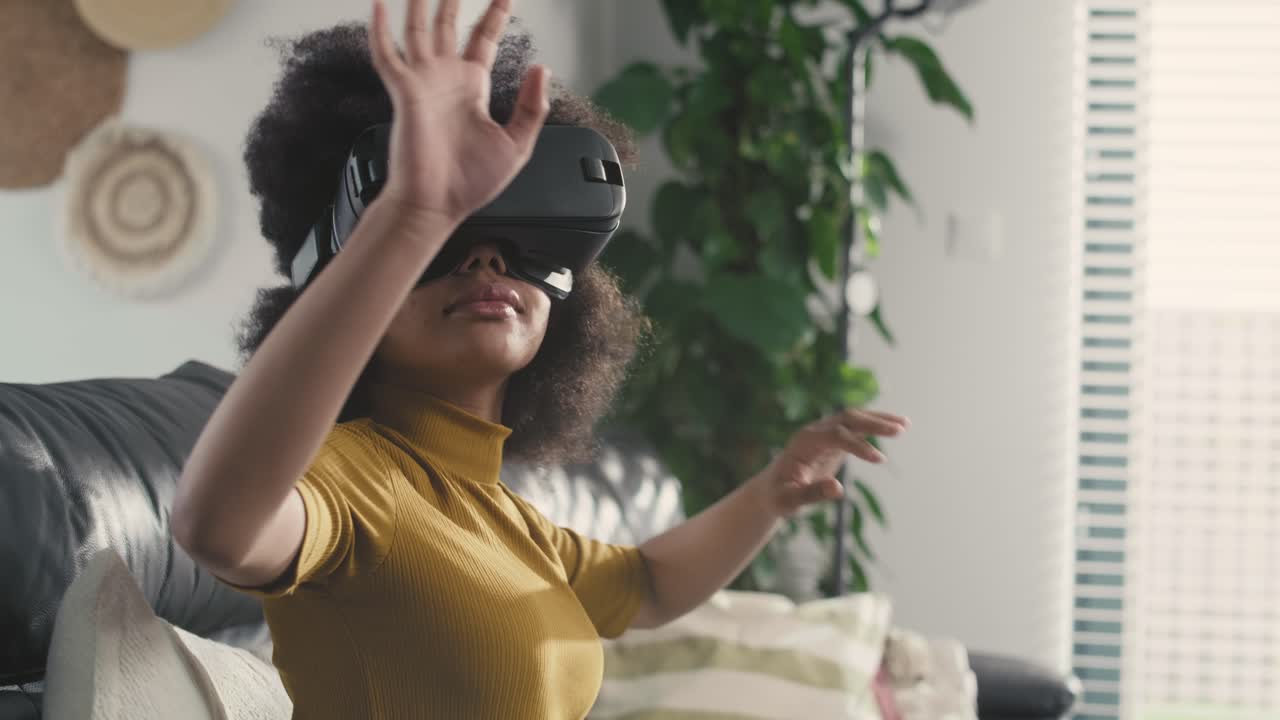 adolescente que usa un simulador de realidad virtual para jugar videojuegos en la sala de estar