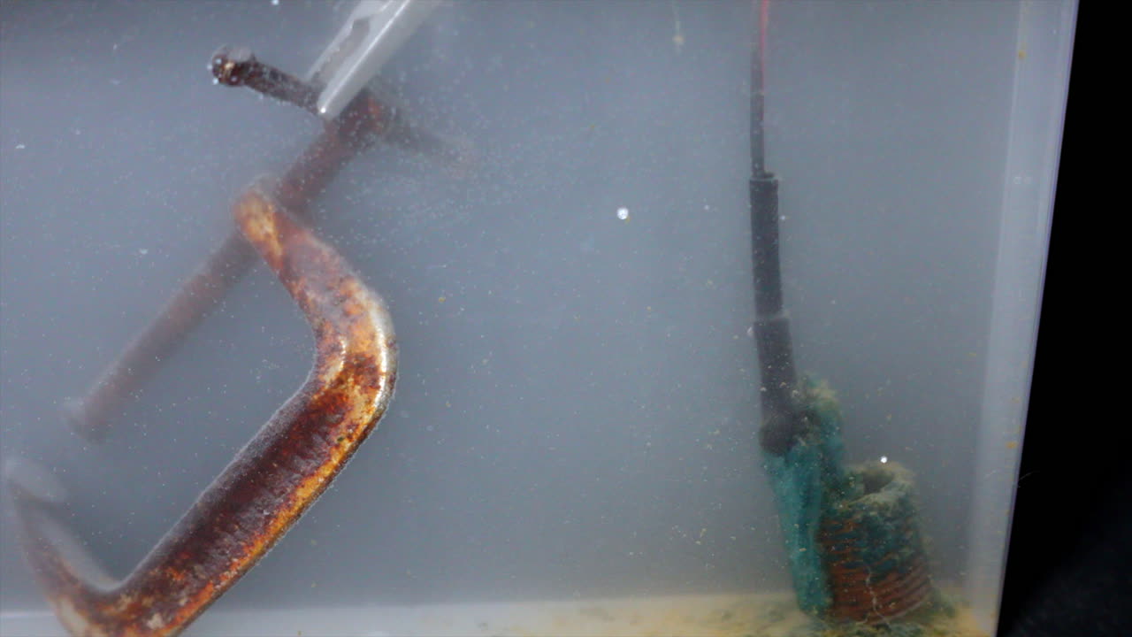 Electrolytic reduction tank with negative electric charge on c-clamp to clean rust off it