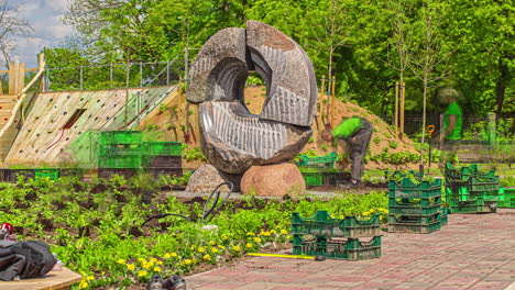 farm workers labor in plantation fields picking crops vegetables besides a statue at daytime in timelapse