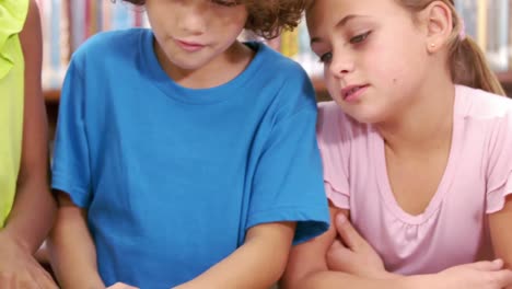 escolares lindos leyendo en su salón de clases