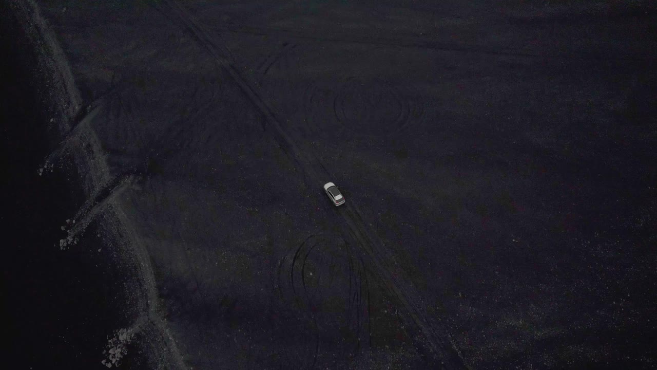 4k 위에서 촬영하는 아이슬란드의 비포장 도로에서 은색 자동차를 따라가는 드론