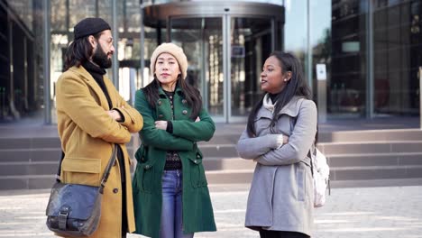 three multicultural international professional coworkers talking near business center. asian caucasian and african american teamwork