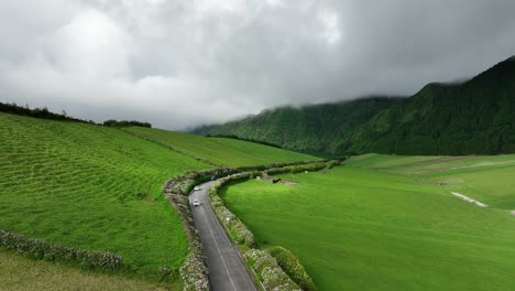 vehicles drive on road through scenic verdure landscape, sete cidades