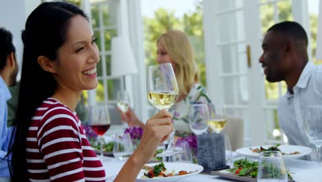 two friends toasting glasses of wine in restaurant