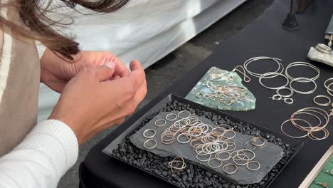 trying on handmade rings at a street vendor booth