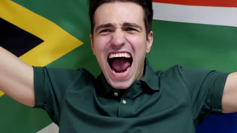 south african young man celebrates holding the flag of south africa in slow motion